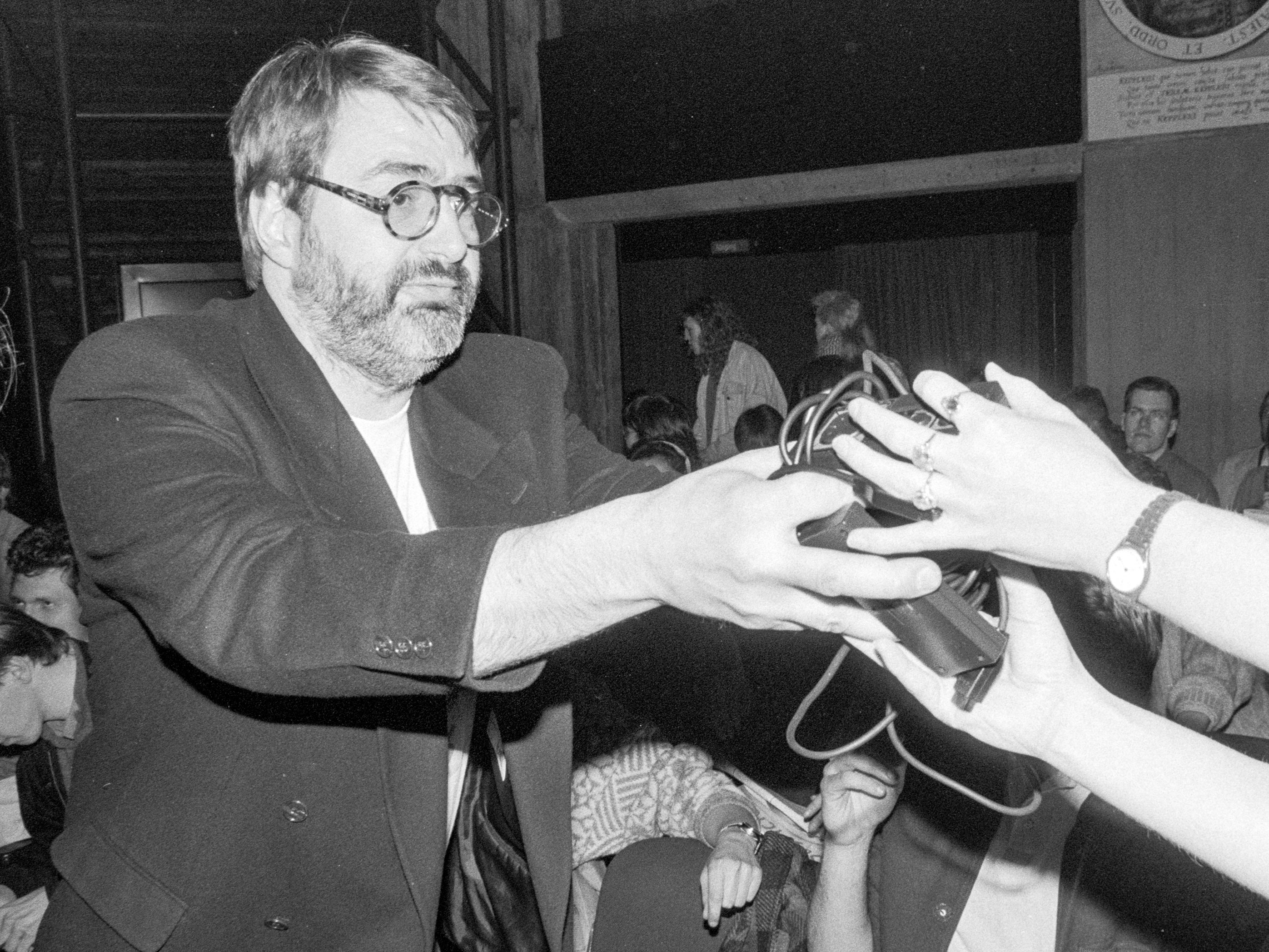 Peter Krieg verteilt Joysticks vor einer ELVIS-Vorführung im Kino. (Schwarzweißbild) (Foto: Martin Frech, 3/1991)