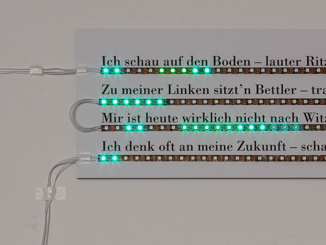 Das erste Quartett des Gedichts »Ich schau auf den Boden – lauter Ritzen.« unterstrichen mit LED-Bändern in Installation.